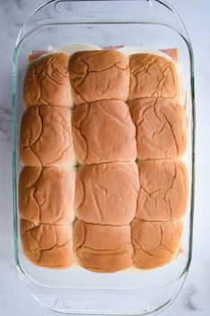 a glass baking dish filled with bread rolls