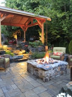 an outdoor fire pit surrounded by furniture and trees