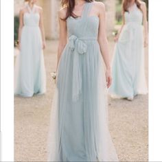 a woman in a blue dress standing next to other women