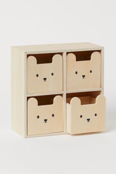 four wooden drawers with faces and ears on the front, one is open to reveal an animal's face