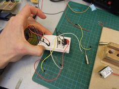 a person is working on an electronic device with wires attached to the back of it