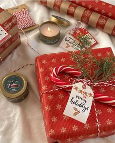 presents wrapped in red paper and tied with twine on top of a white sheet