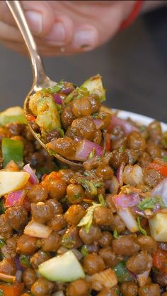 a spoon full of food that is being held up by someone's hand,