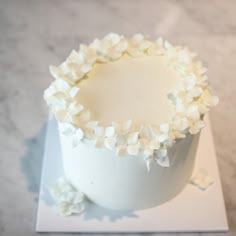 a cake with white frosting and flowers on top