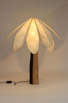 a lamp that is sitting on top of a wooden stand with a cord attached to it