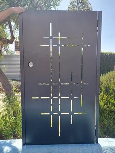 a person is holding up a metal door with squares on it and holes in the side