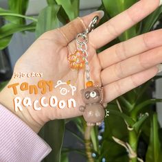 a hand holding a keychain with an animal on it