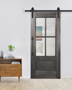 an empty room with a wooden dresser and sliding glass door