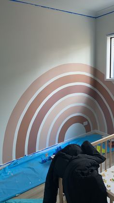 a baby crib in the corner of a room painted with brown and white circles