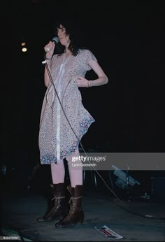 a woman standing on stage holding a microphone