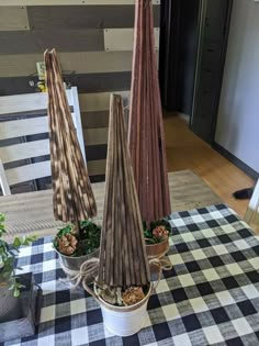 two potted plants sitting on top of a checkered table cloth