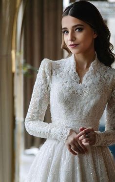 a woman in a white dress is posing for the camera with her hands on her hips