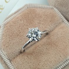 a diamond ring sitting on top of a pillow