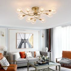 a living room filled with furniture and a chandelier hanging from the ceiling above