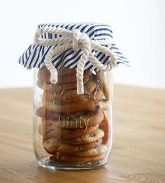 a jar filled with cookies sitting on top of a wooden table