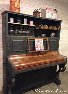 an old piano is sitting in front of a book shelf with books on it and other items