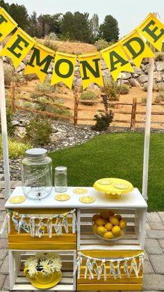 an outdoor lemonade stand with yellow and white decorations