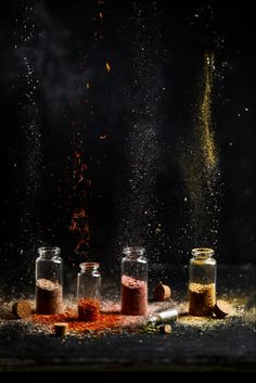 three jars filled with different types of spices and sprinkles on a table