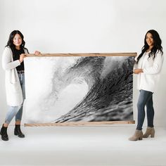 two women holding up a large black and white photo