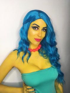 a woman with blue hair wearing a green top