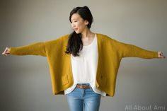 a woman with her arms spread out in front of her is wearing a yellow cardigan