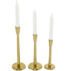 three brass candlesticks on white background