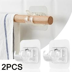 two pieces of white towel hanging on the wall next to each other with wooden handle