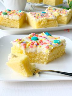 a piece of cake with white frosting and sprinkles is on a plate