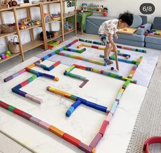 a child playing in a play room with colored blocks on the floor and toys all around