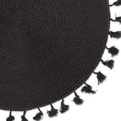 a round black rug with tassels on it