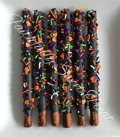 several sticks with sprinkles on them are arranged in a row