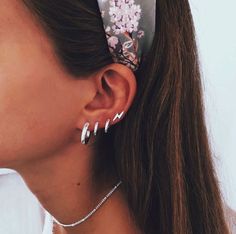 a woman wearing ear clips with flowers on them