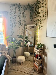 a living room filled with lots of plants next to a mirror and bookshelf