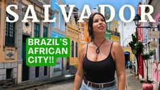 a woman standing in the middle of a street with colorful buildings behind her and a sign that says salvador brazil's african city