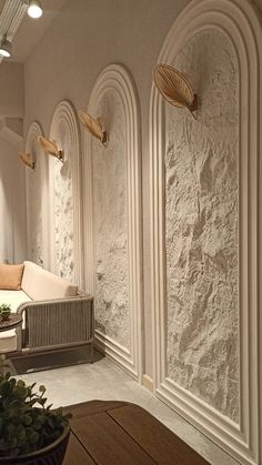 a living room with white walls and wooden furniture on the floor, along with decorative wall sconces