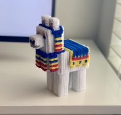 a toy horse made out of pipe cleaners on top of a counter next to a window