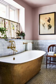 an old fashioned bathtub in a bathroom with pink walls