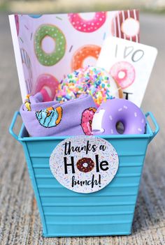 a blue basket filled with donuts and doughnuts on top of a table