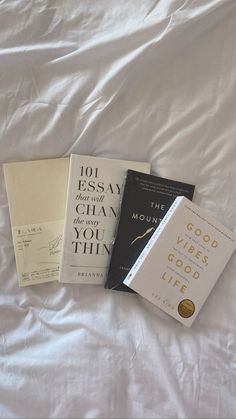 three books laying on top of a bed next to each other