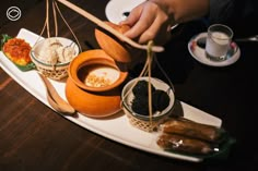 a person balances food on a plate with chopsticks and spoons next to them