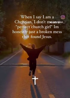 a person is running down the street with their arms in the air and there is a cross at the end of the road