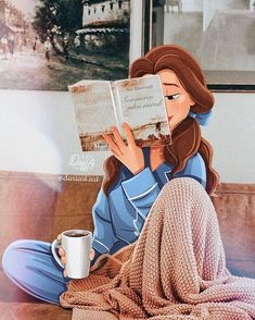 a woman sitting on top of a couch reading a book and holding a coffee cup