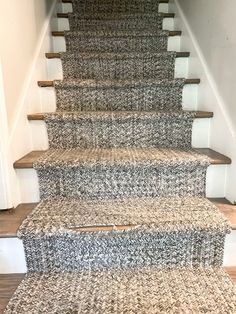 a carpeted stair runner on the bottom of a set of stairs in a home