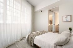 a bedroom with a bed and white curtains