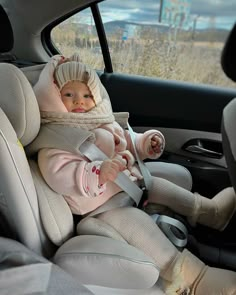 a baby sitting in the back seat of a car