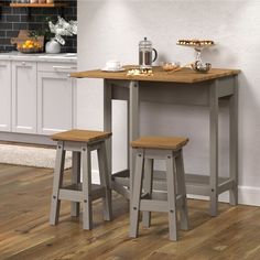 two stools sitting at a kitchen table with food on the counter and potted plant next to it