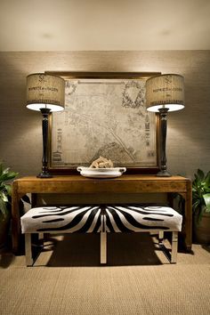 a table with two lamps on it and a zebra print bench in front of it