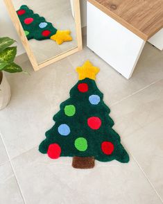 a christmas tree rug on the floor next to a mirror