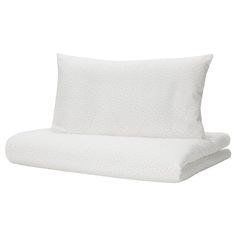 two white pillows sitting next to each other on top of a pillow case with polka dot print