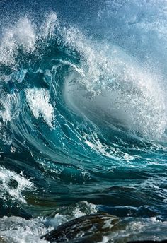 an ocean wave is breaking over the top of it's head in blue water